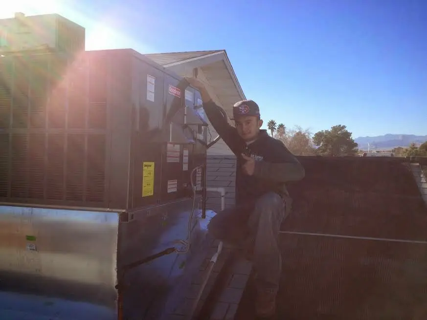 HVAC technician performing HVAC Inspection on a rooftop unit in Sutherlin